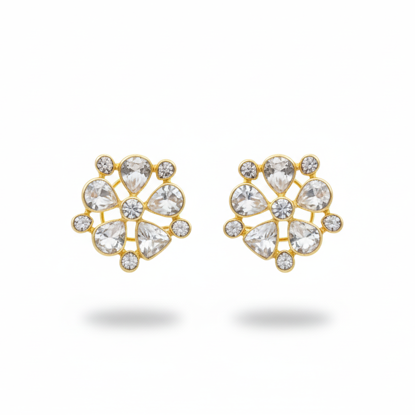 Pair of gold earrings with clear gemstones on a white background