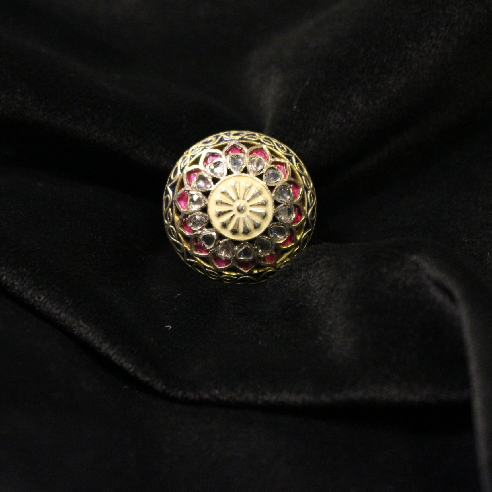 Gold ring with gemstones on a black velvet background