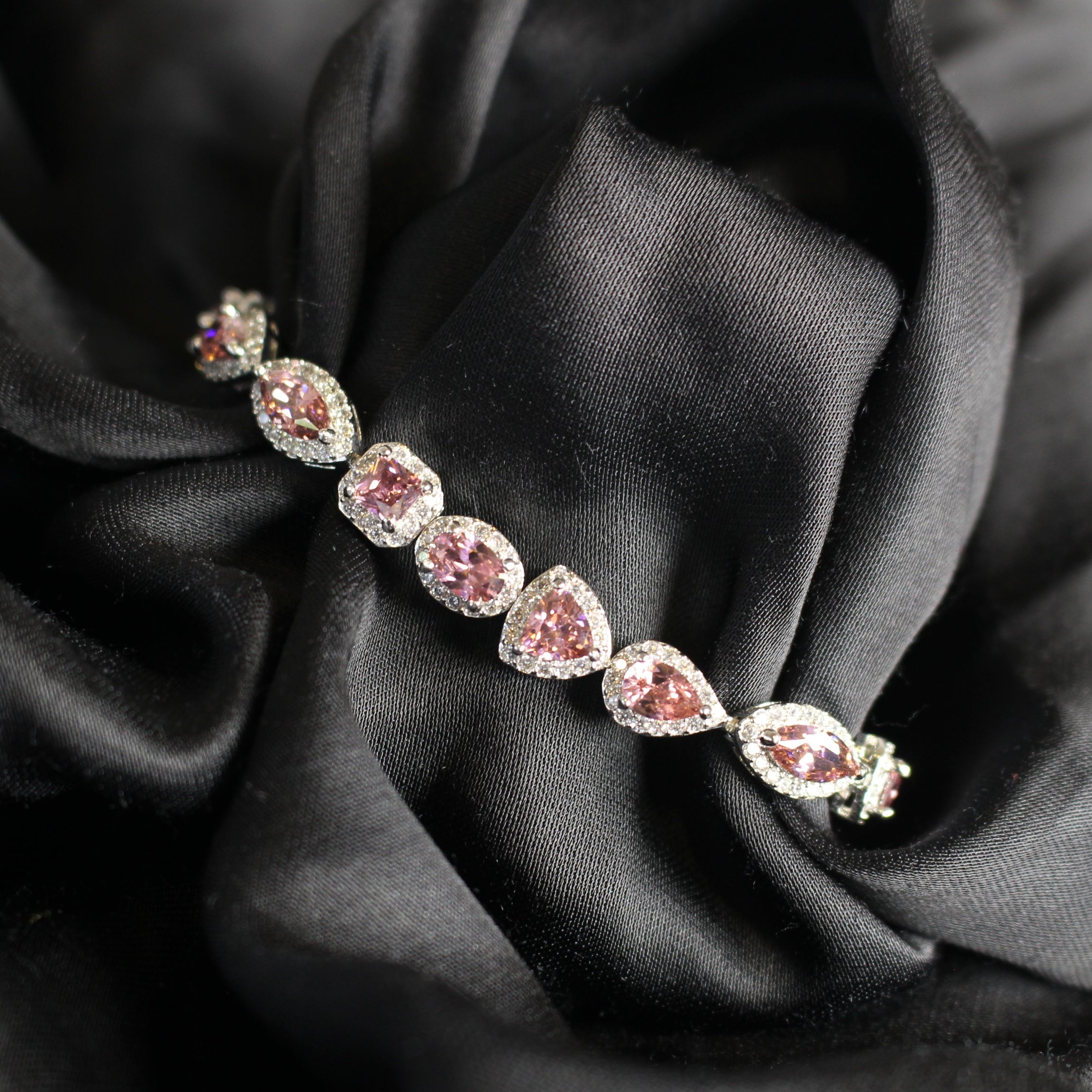 Bracelet with pink gemstones on a black fabric background