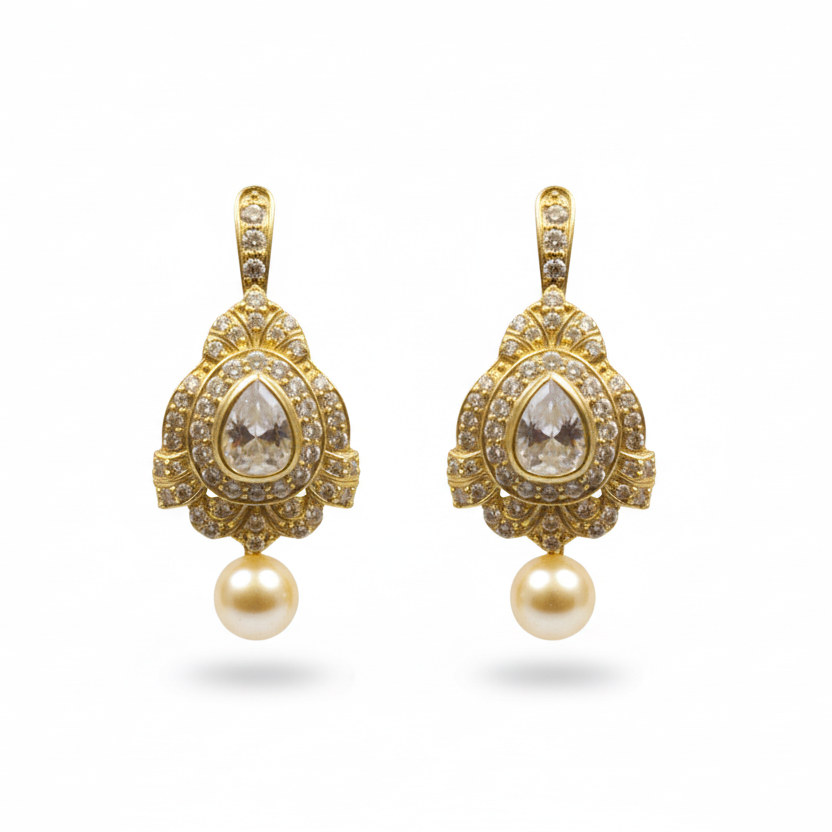 Pair of gold earrings with teardrop-shaped gemstones and pearl drops on a white background